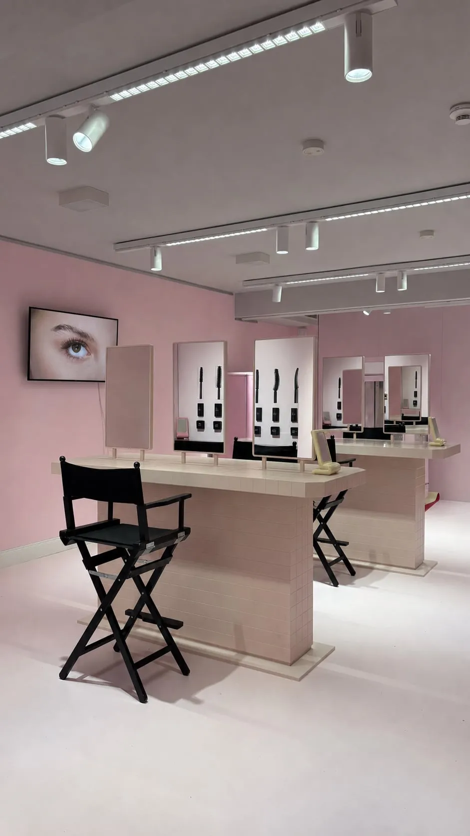 Rosafarbener Make-up-Raum mit Regiestühlen und Schminkstationen