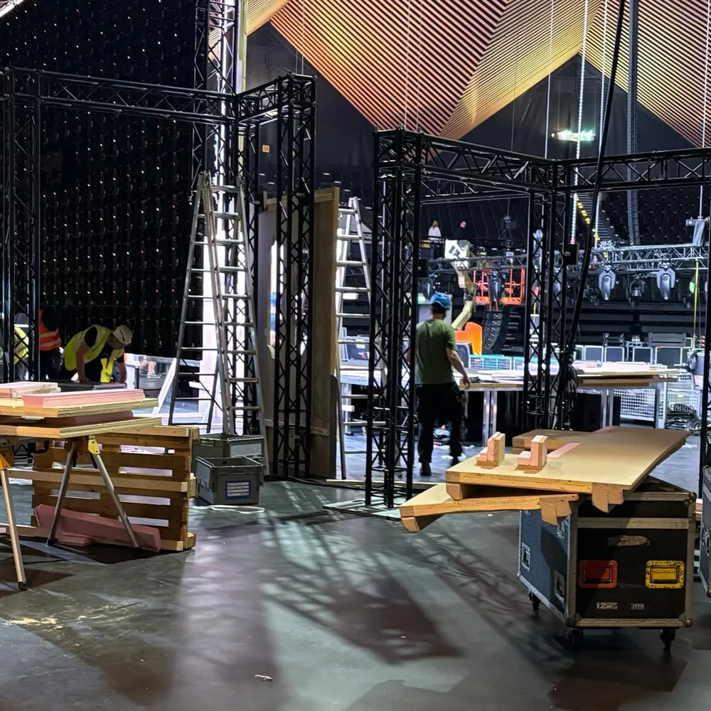 Aufbau vor einem Event: Traversen, Leitern und Cases, dazwischen Crew bei der Arbeit