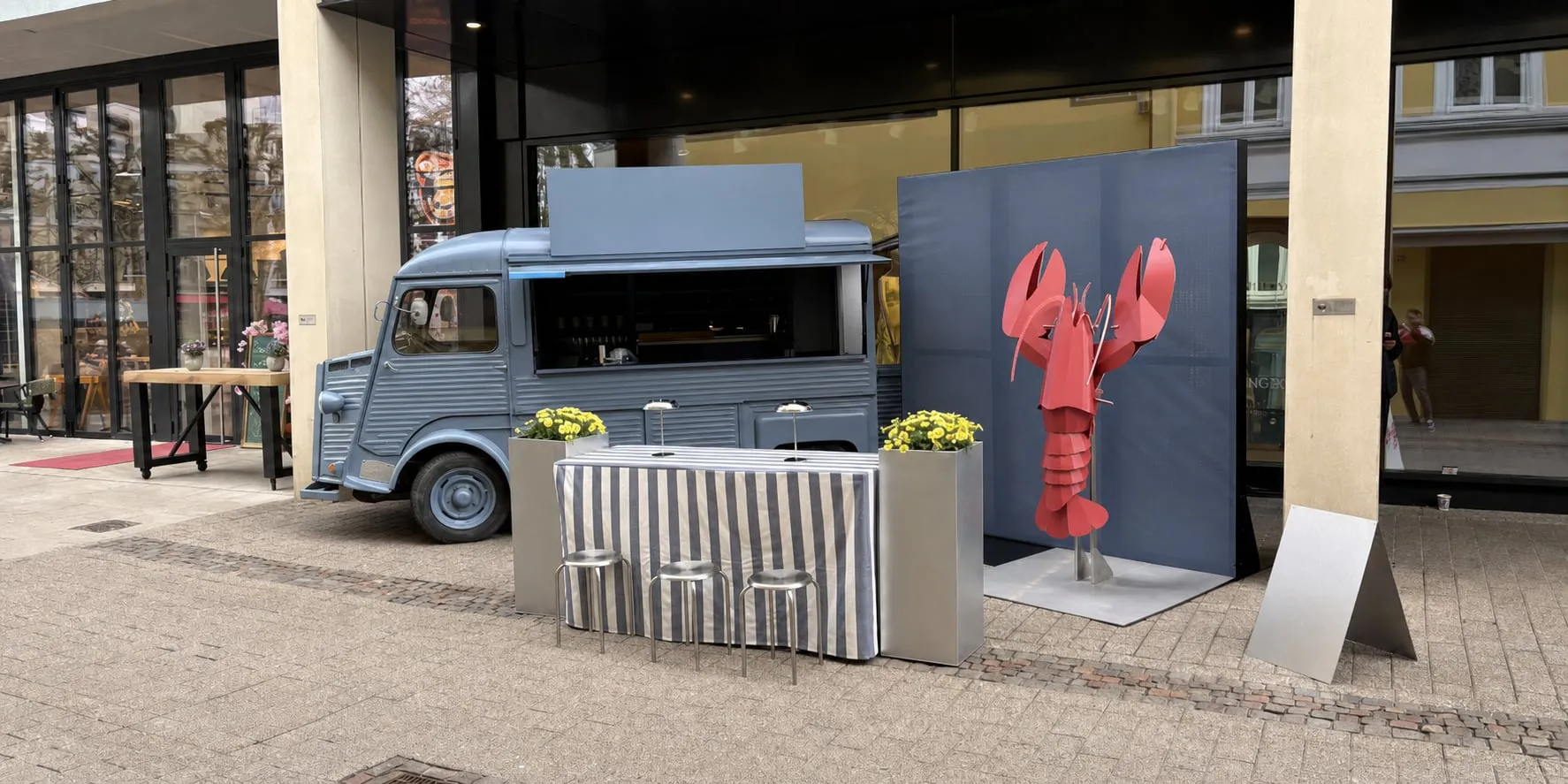 Neutralisierte temporäre Außenaktivierung mit Foodtruck und Skulptur