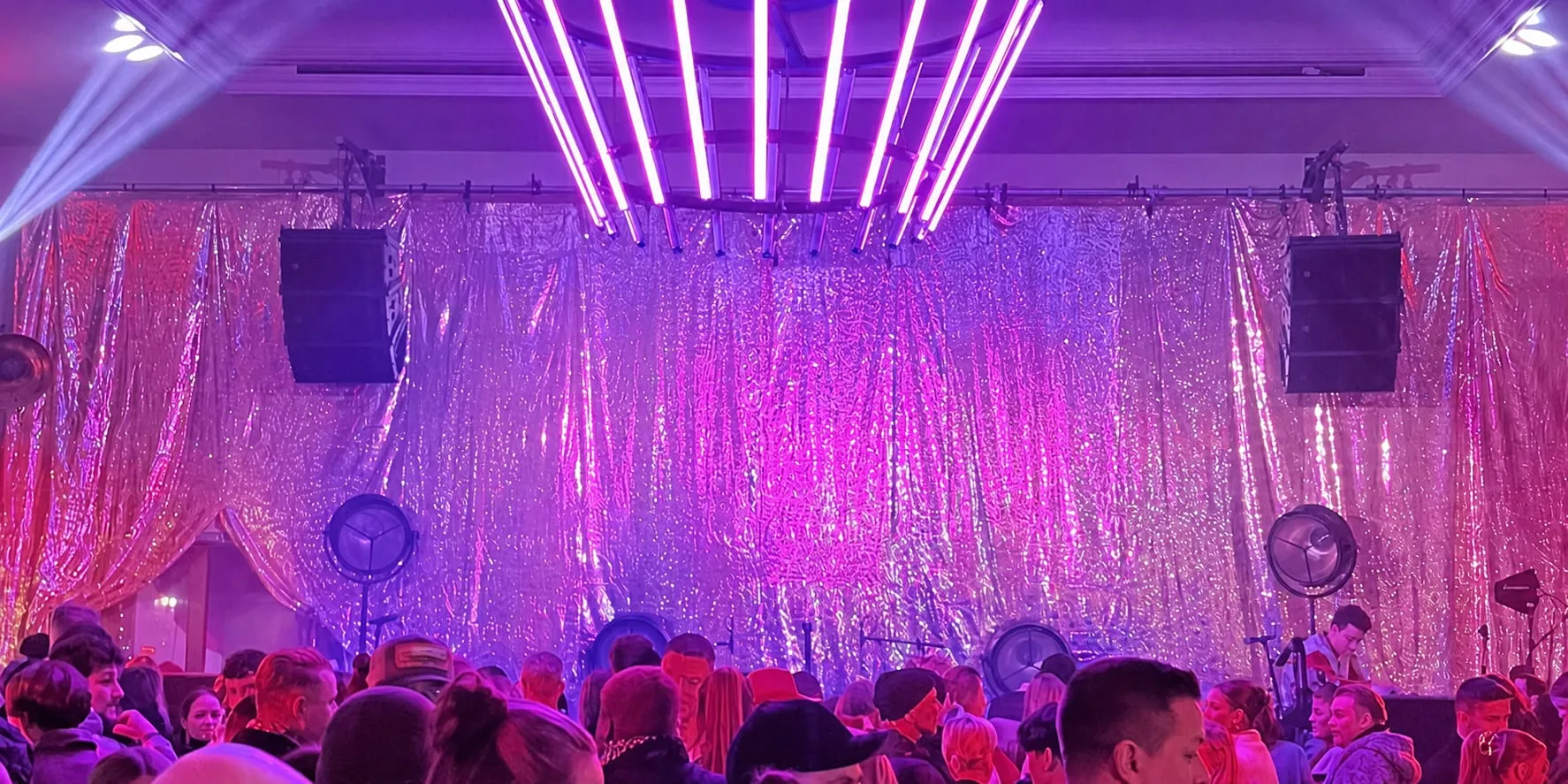 Neutralisiertes Publikum vor einer illuminierten Eventbühne
